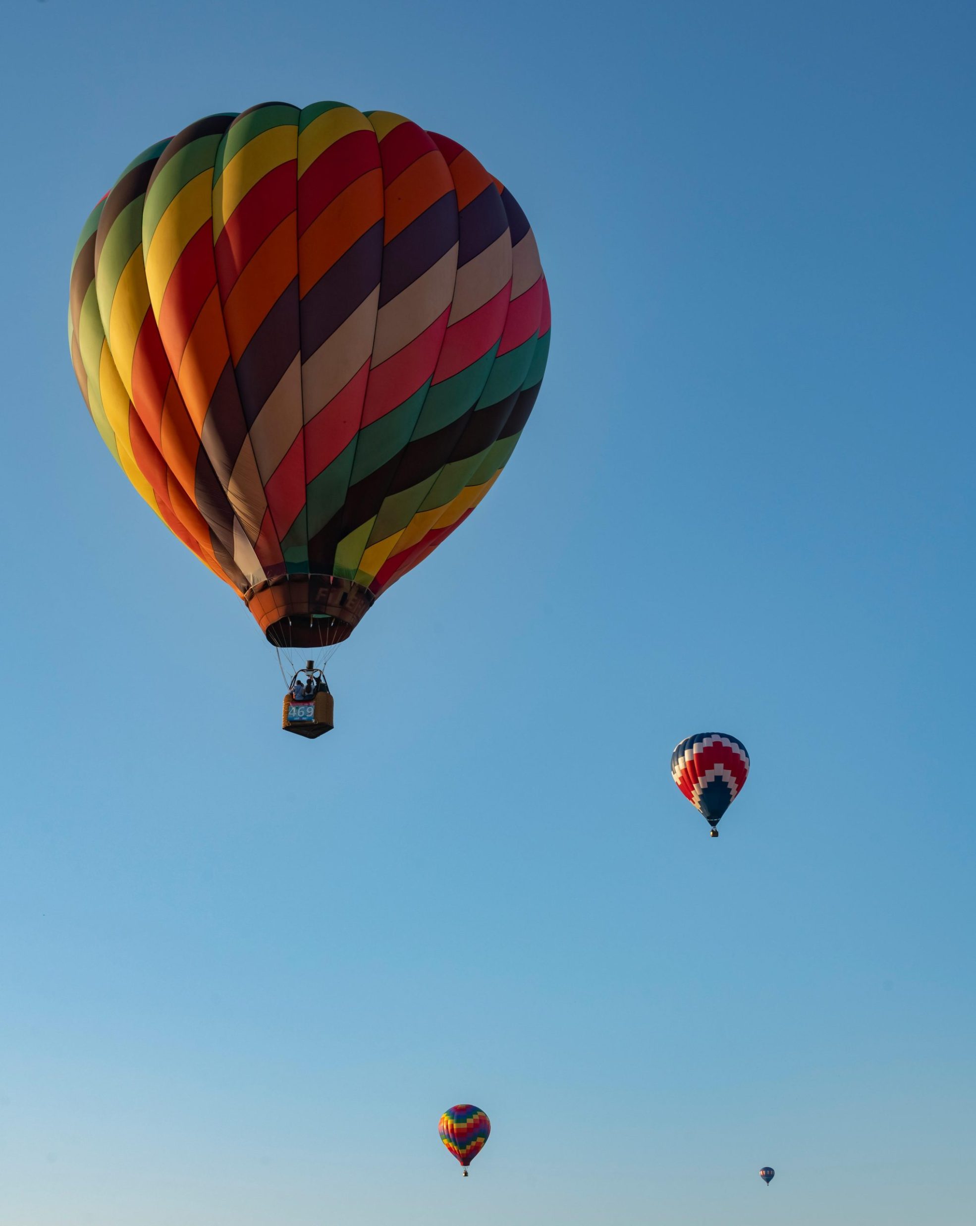Vibrant hot air balloons flying against a clear blue sky in Rhinebeck, NY.