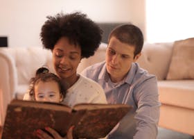 A happy family reads together on a comfortable sofa, showcasing love and togetherness.